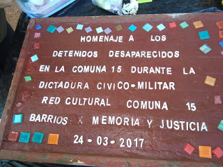 Colocación de baldosa en homenaje a desaparecidos en la Comuna 15